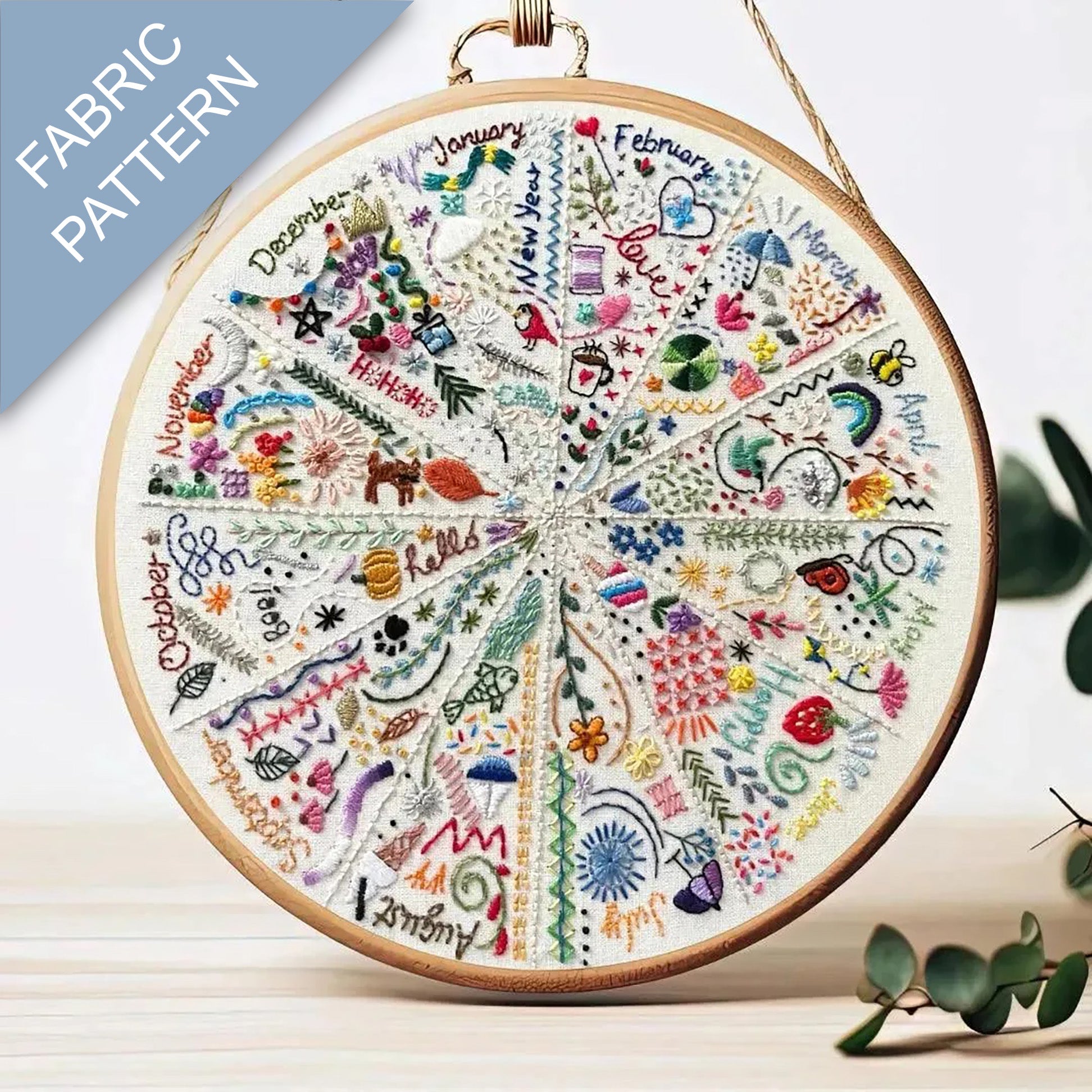 Embroidery hoop with a colorful fabric pattern featuring months of the year.