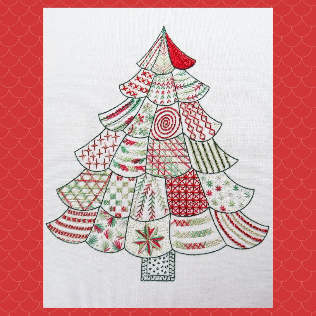 A festive Christmas tree artwork made of layered quilted fabric panels in red, green, and white patterns, centered on a white rectangular canvas with a red scalloped border.
