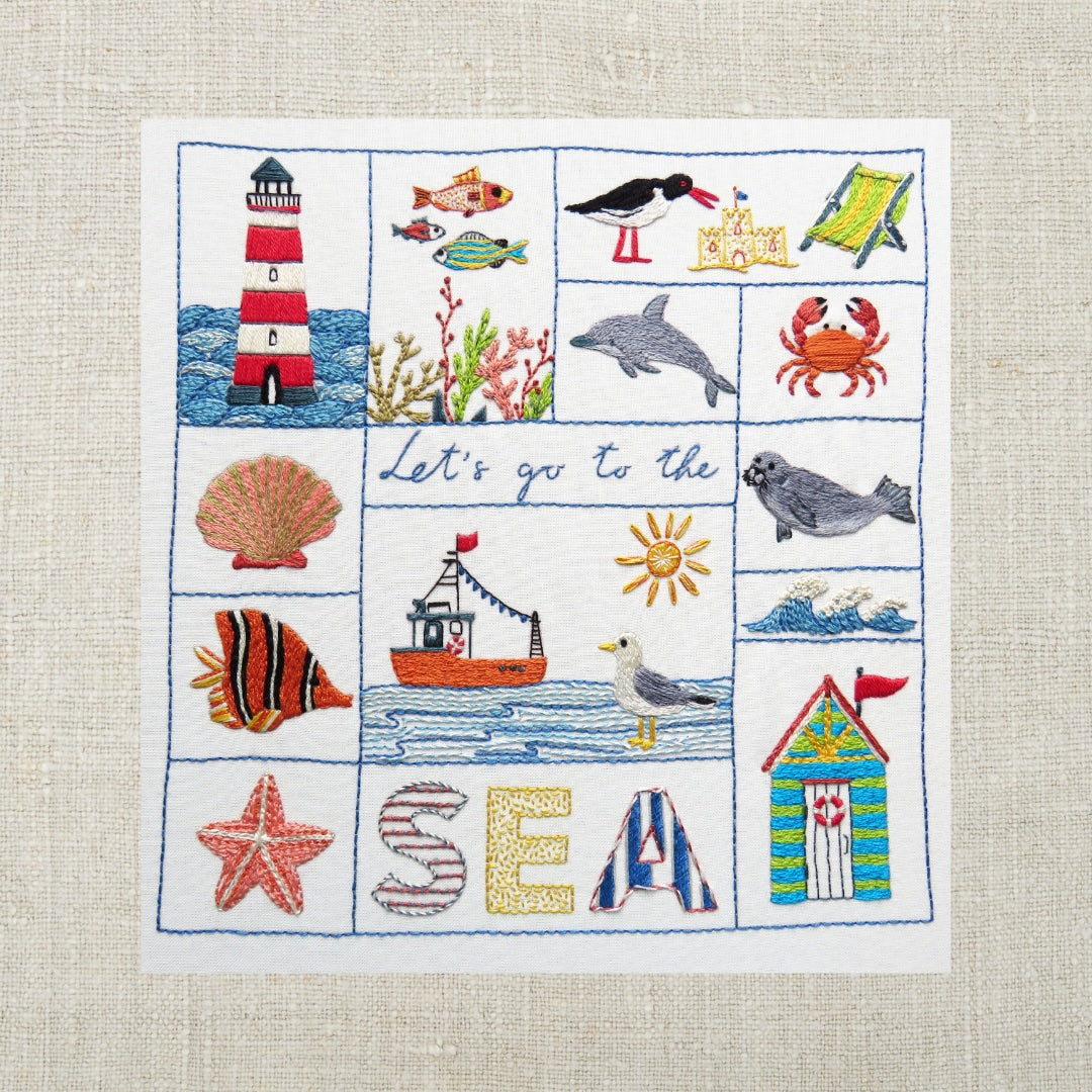 Embroidered panel with sea-themed designs on a textured fabric background