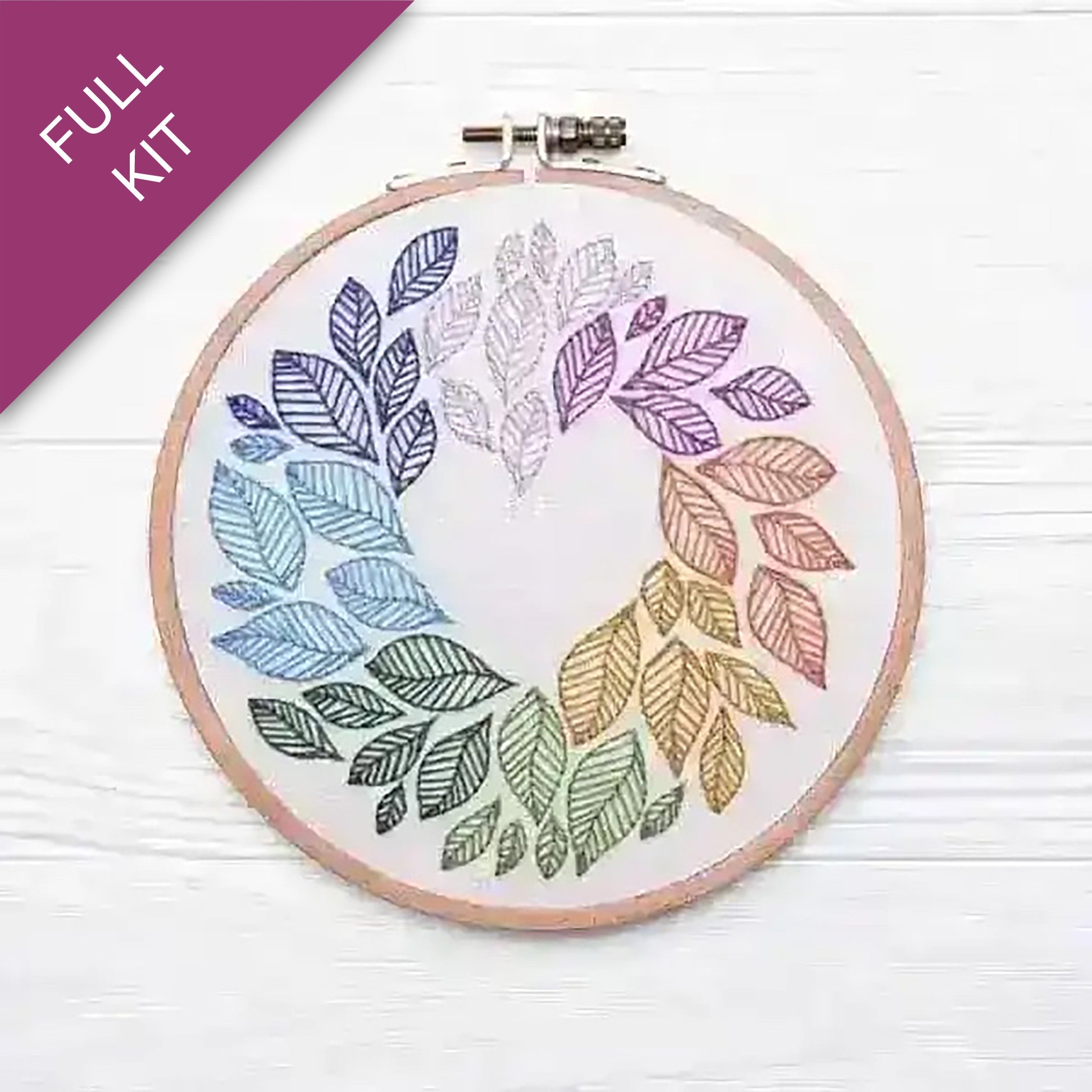 Embroidery hoop with colorful leaf patterns on a white background