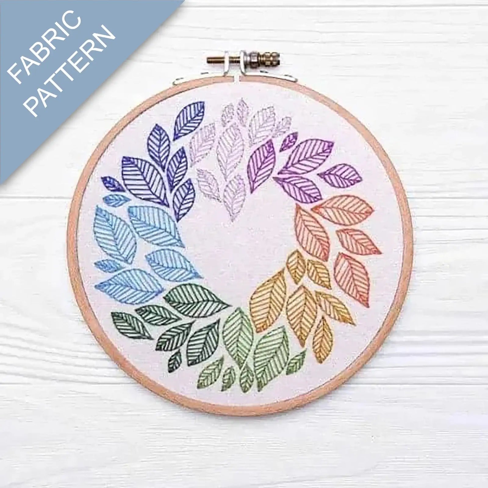 Embroidery hoop with colorful leaf pattern on fabric, labeled 'Fabric Pattern'.