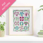 Framed floral pattern on a white wall with plants and books in the background