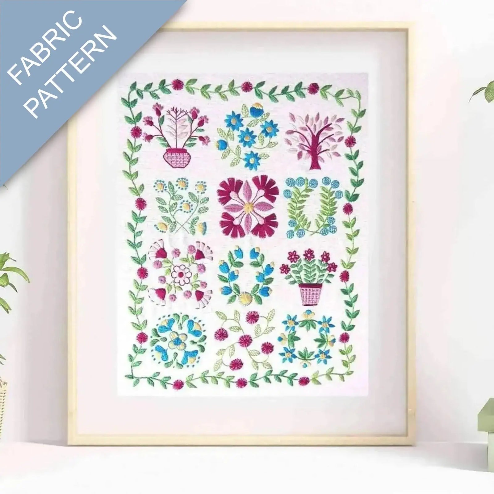 Framed fabric pattern with floral and plant designs on a white background