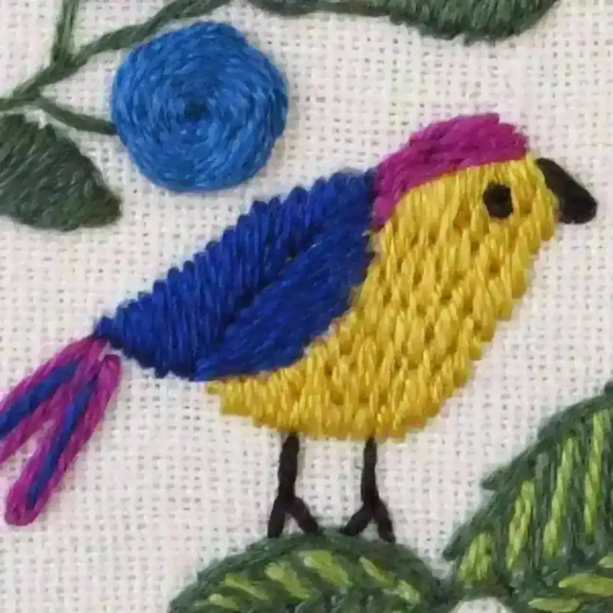 Embroidered design of a bird with blue, yellow, and pink colors on a white background.