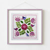 Embroidered square with flowers and birds in a pink frame on a white background