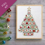 Framed Christmas tree design with decorative elements on a wooden surface.
