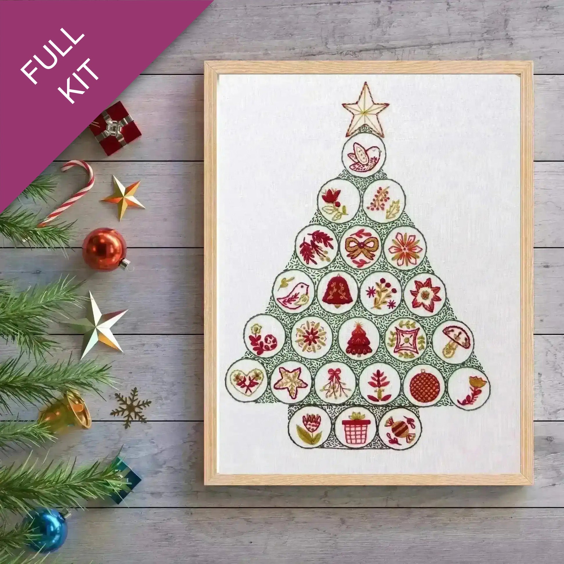 Framed Christmas tree design with decorative elements on a wooden surface.