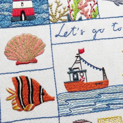 Embroidered panel with sea-themed designs including a fish, boat, and seagull.