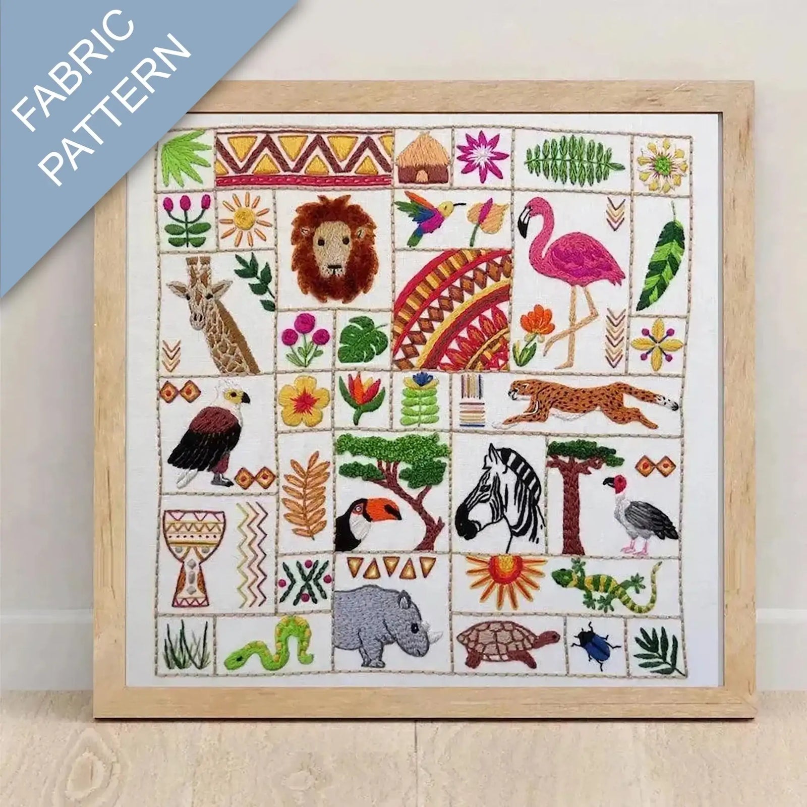 Embroidered fabric pattern with animals and nature elements framed in a wooden frame.