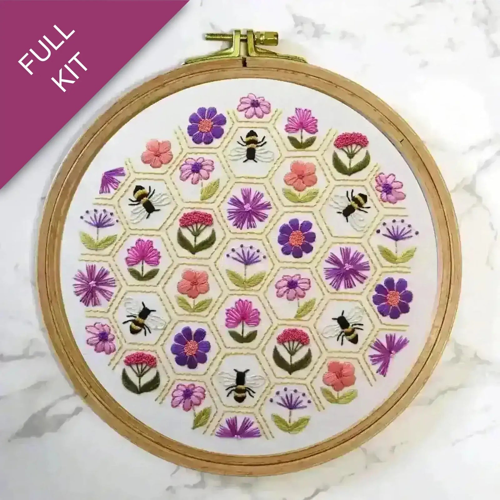 Embroidery hoop with floral and bee pattern on a white background