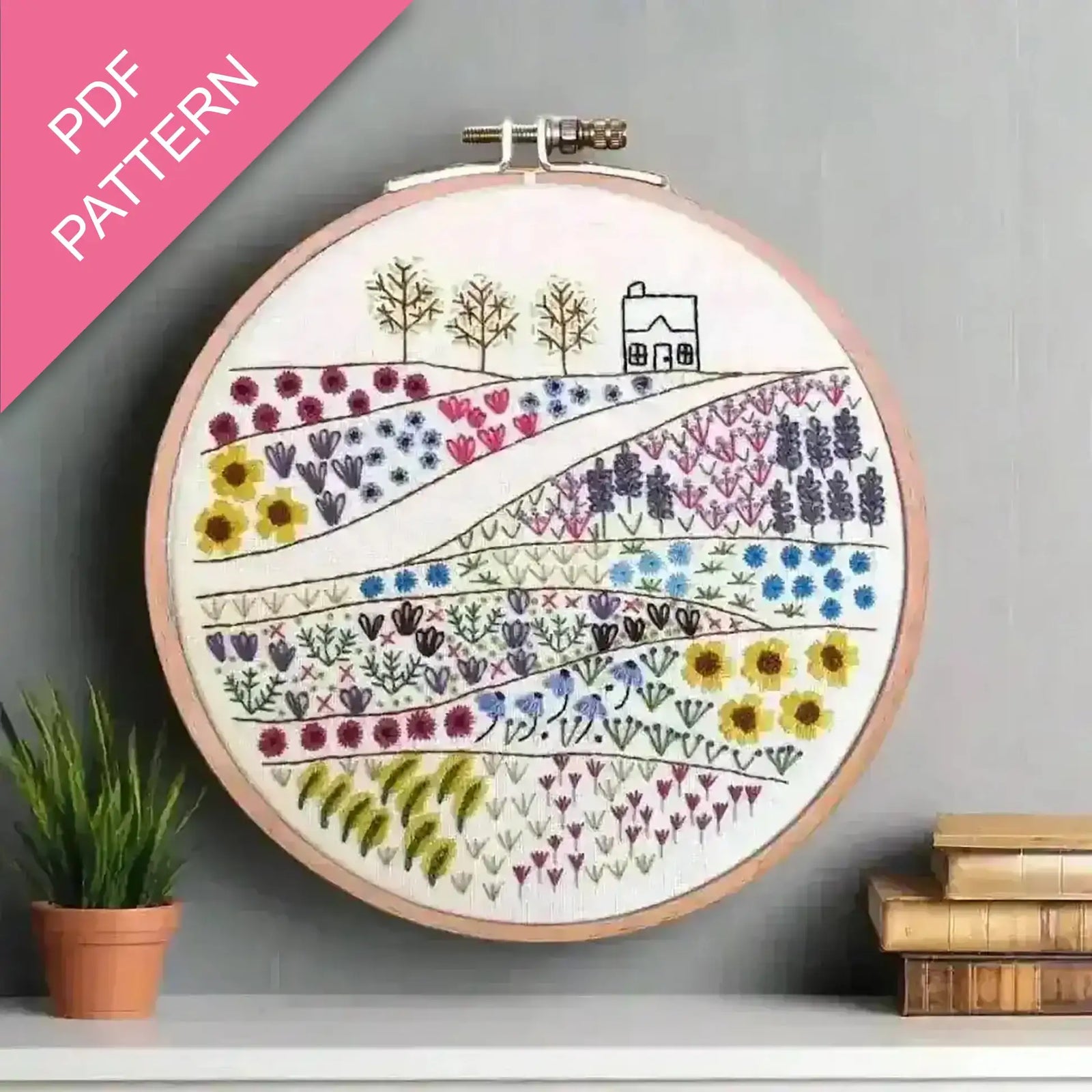 Embroidery hoop with floral and landscape design on a gray wall, featuring 'PDF Pattern' text.