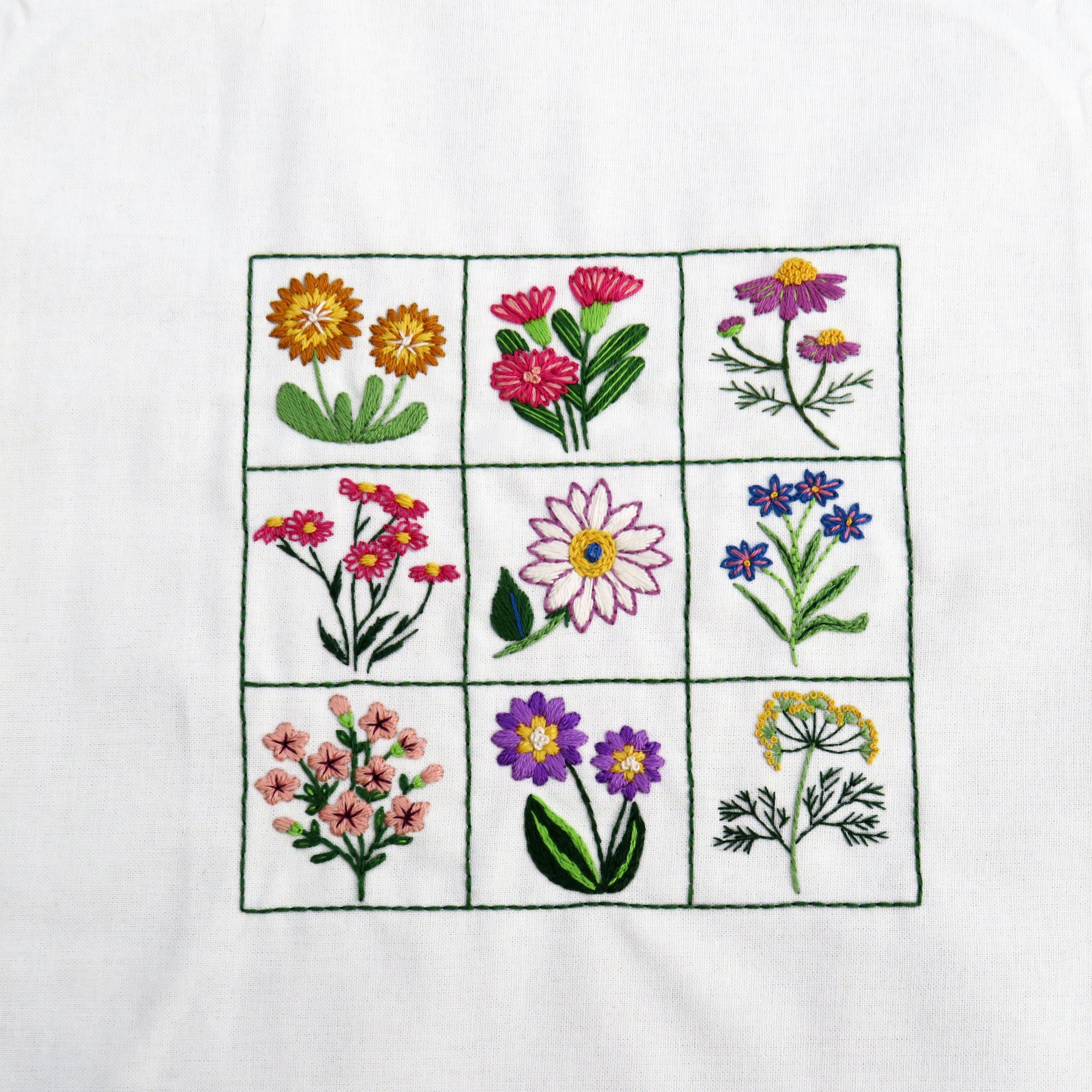 Embroidered pattern of various flowers on a white fabric