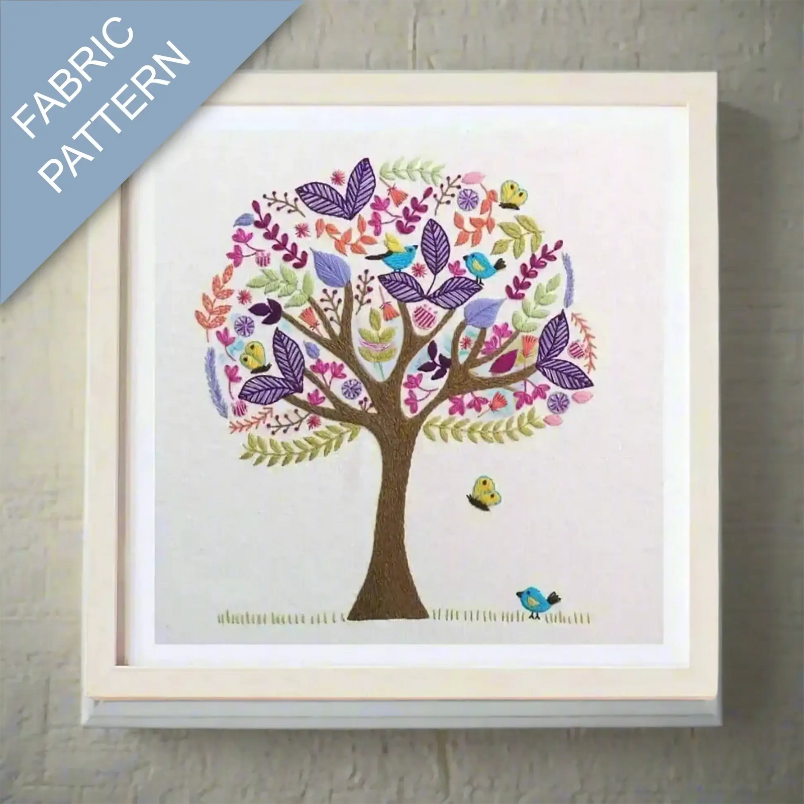 Framed fabric pattern with a colorful tree design on a textured wall.