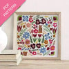 Embroidery pattern with colorful flowers and plants in a wooden frame on a white surface.