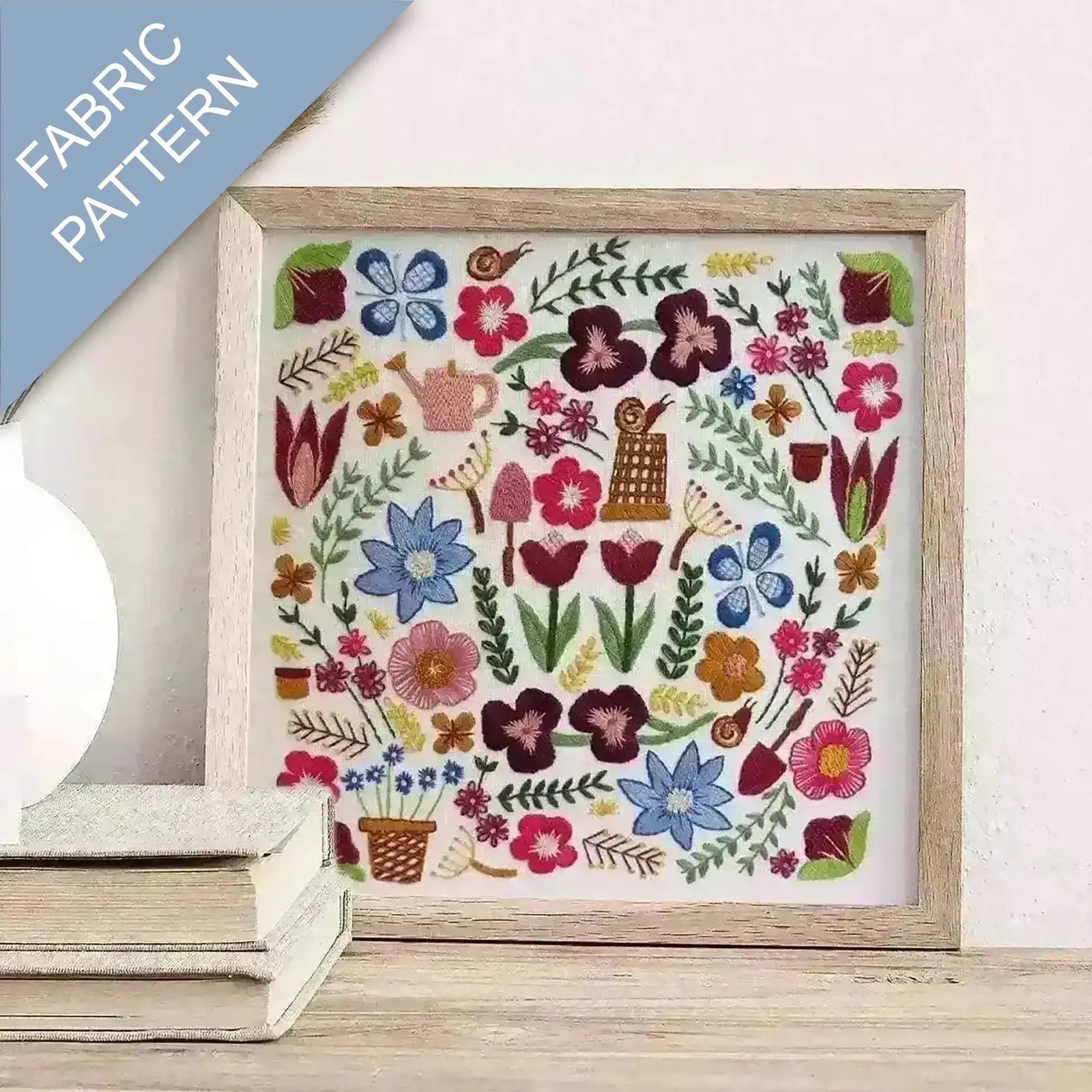 Framed fabric pattern with colorful floral and gardening-themed design on a white background.