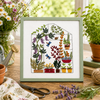 Embroidery of a greenhouse with plants on a wooden table with flowers and plants around.