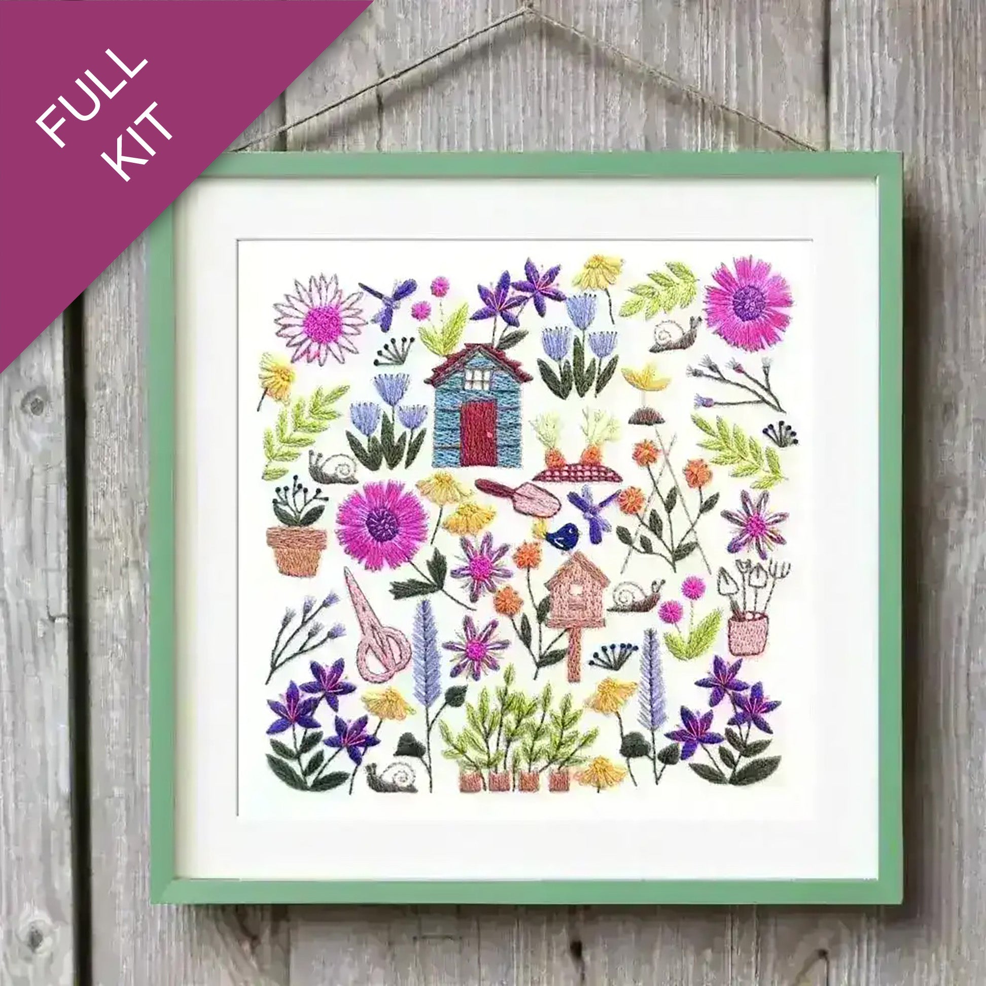 Embroidery kit with colorful garden scene on a wooden surface