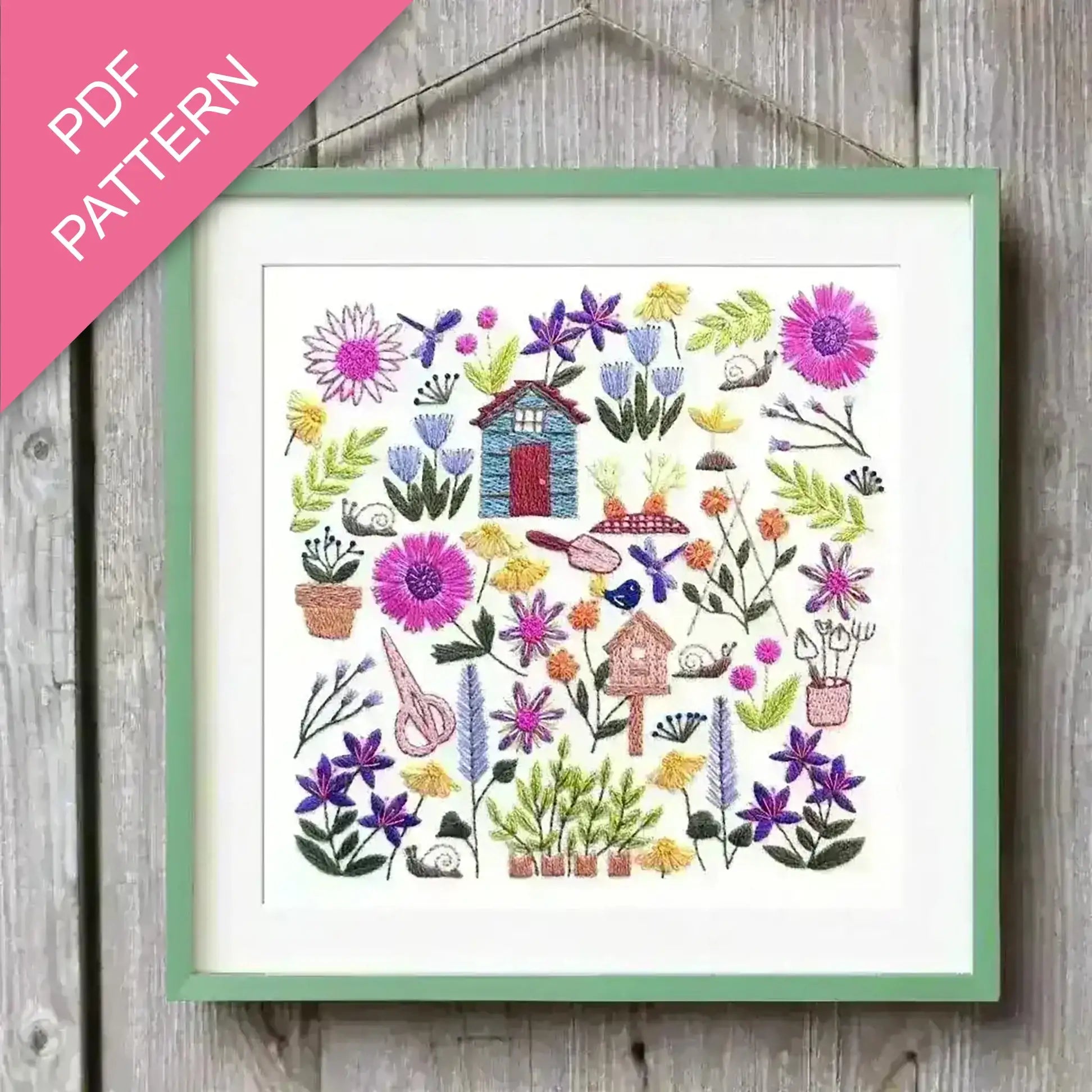 Embroidery pattern with flowers and small houses on a wooden background, labeled 'PDF Pattern'.