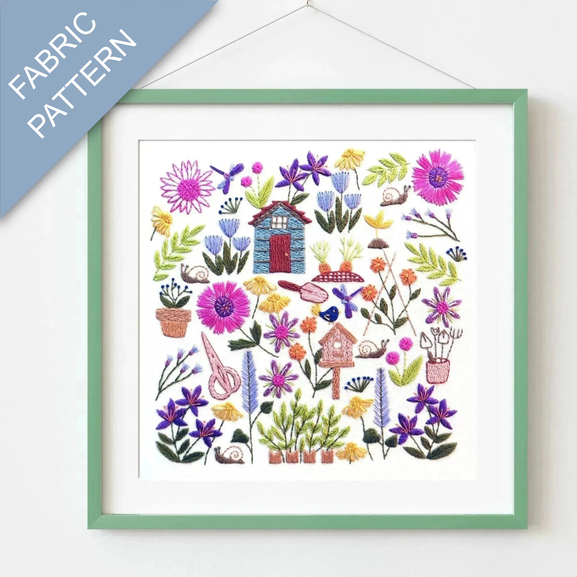Framed fabric pattern with colorful flowers and small houses on a white background