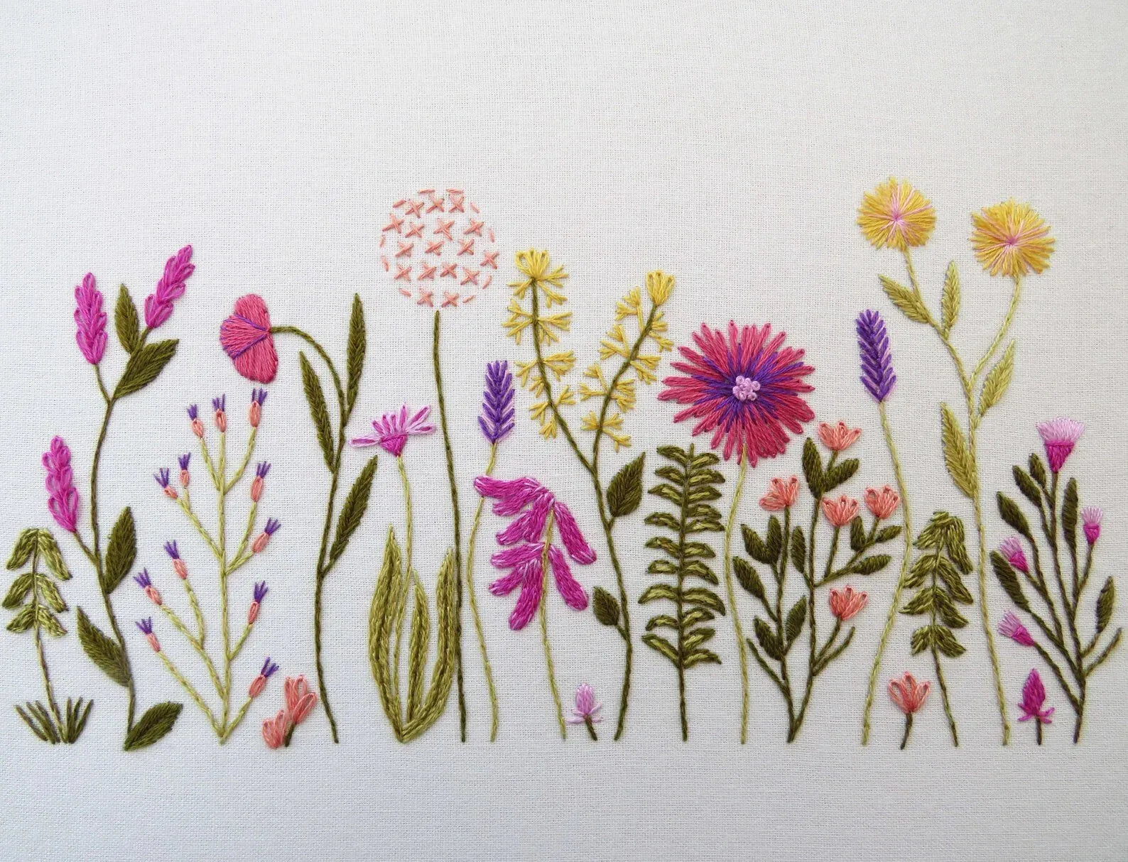 Embroidered design of various flowers on a white background