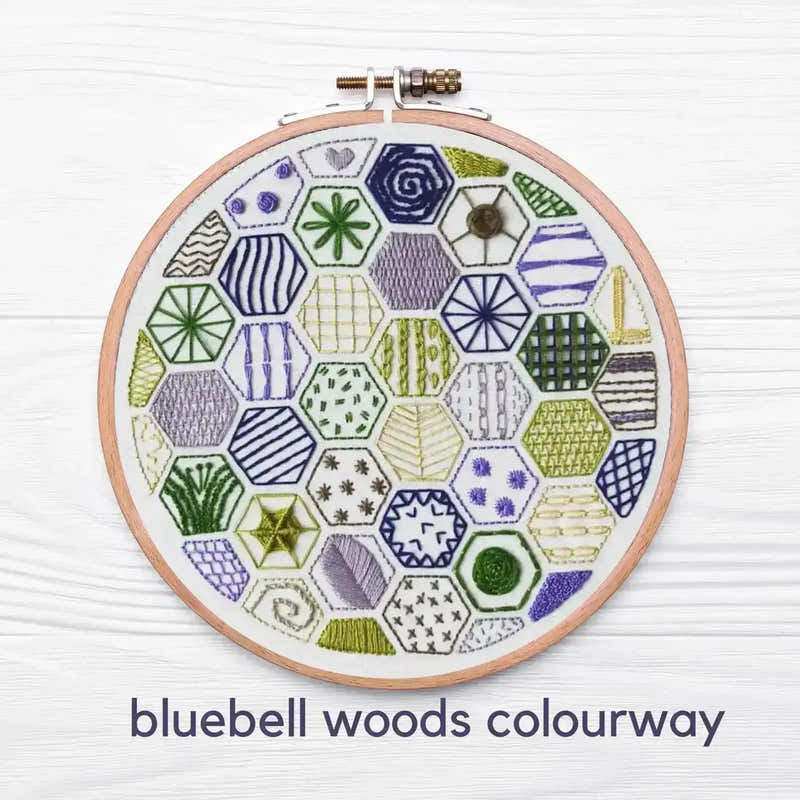 Embroidery hoop with geometric pattern on a white background, labeled 'bluebell woods colourway'.