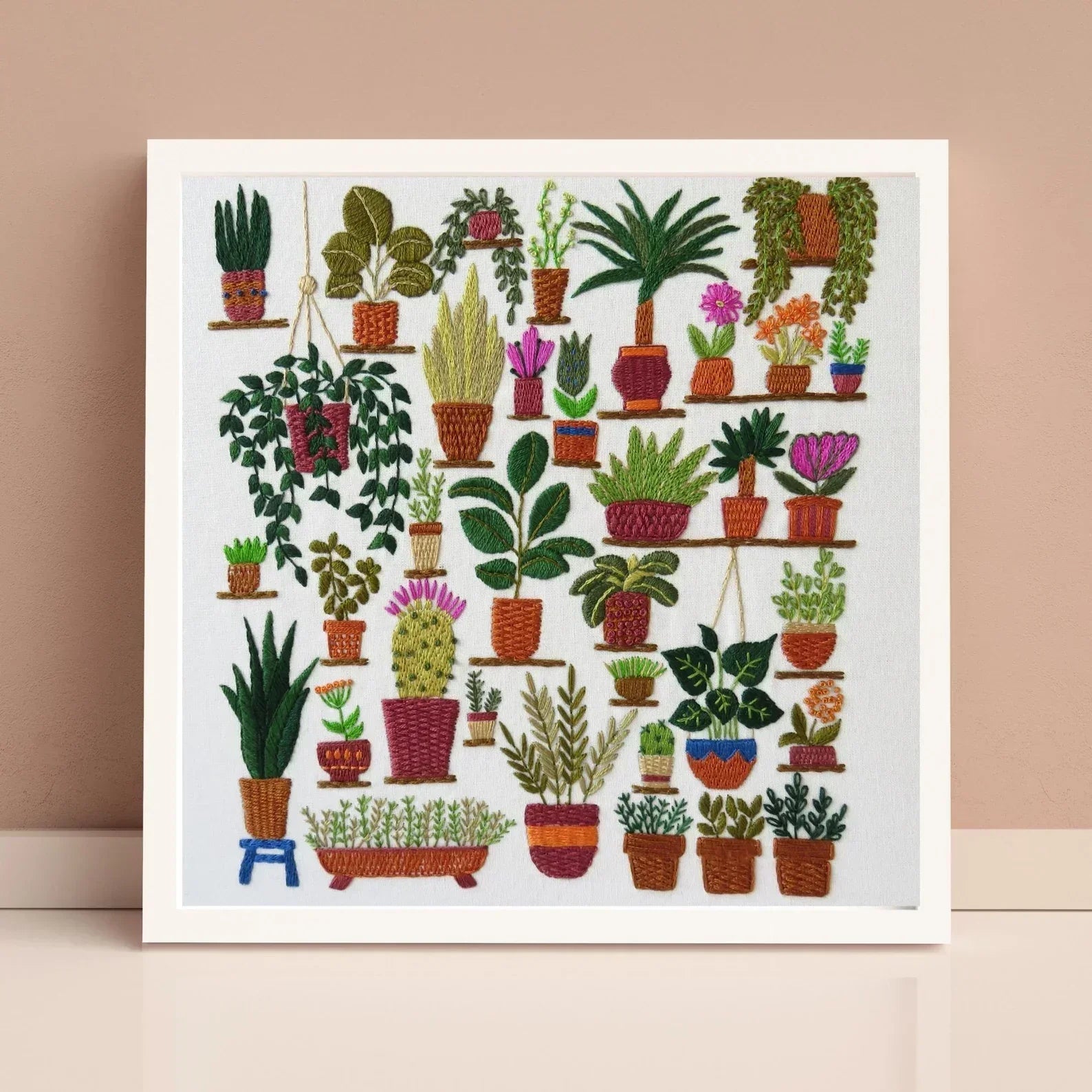 Framed artwork of various potted plants on a beige background