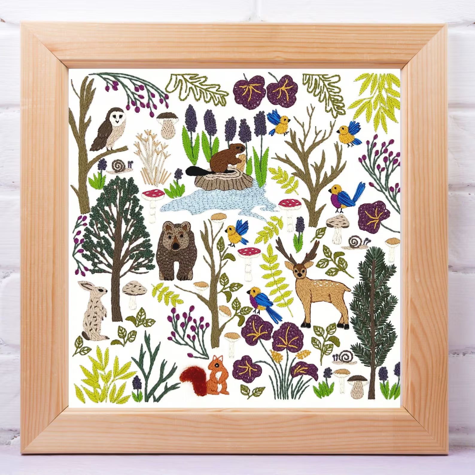 Framed artwork with forest animals and plants on a white background