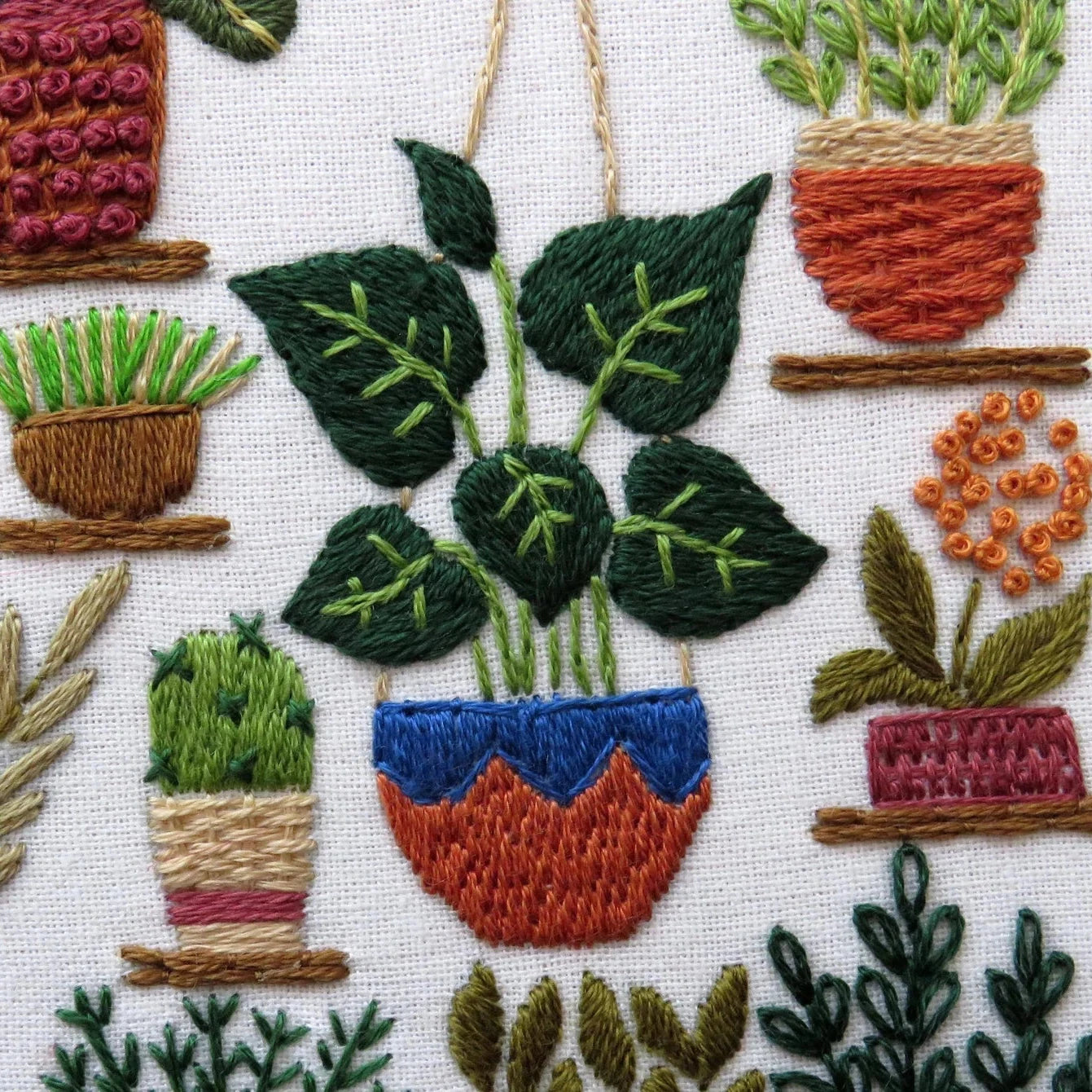 Embroidered pattern of potted plants on a white background