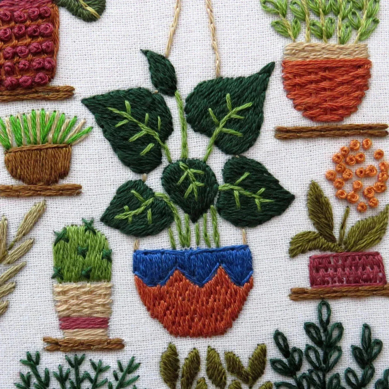 Embroidered pattern of potted plants on a white background