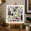 Art print on a small easel in a home office setting with decor items.