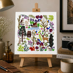 Art print on a small easel in a home office setting with decor items.