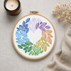 Embroidery hoop with colorful leaf pattern on a neutral background