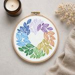 Embroidery hoop with colorful leaf pattern on a neutral background