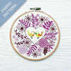 Embroidery hoop with floral and bird design on a white background