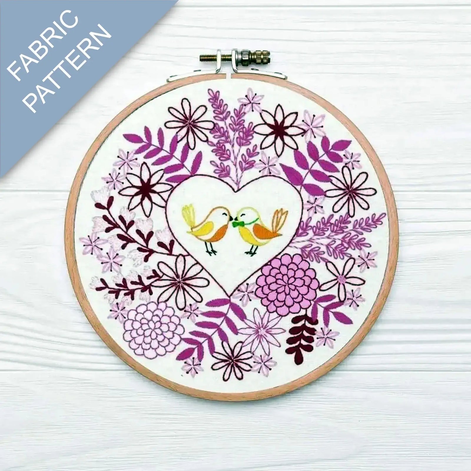 Embroidery hoop with floral and bird design on a white background