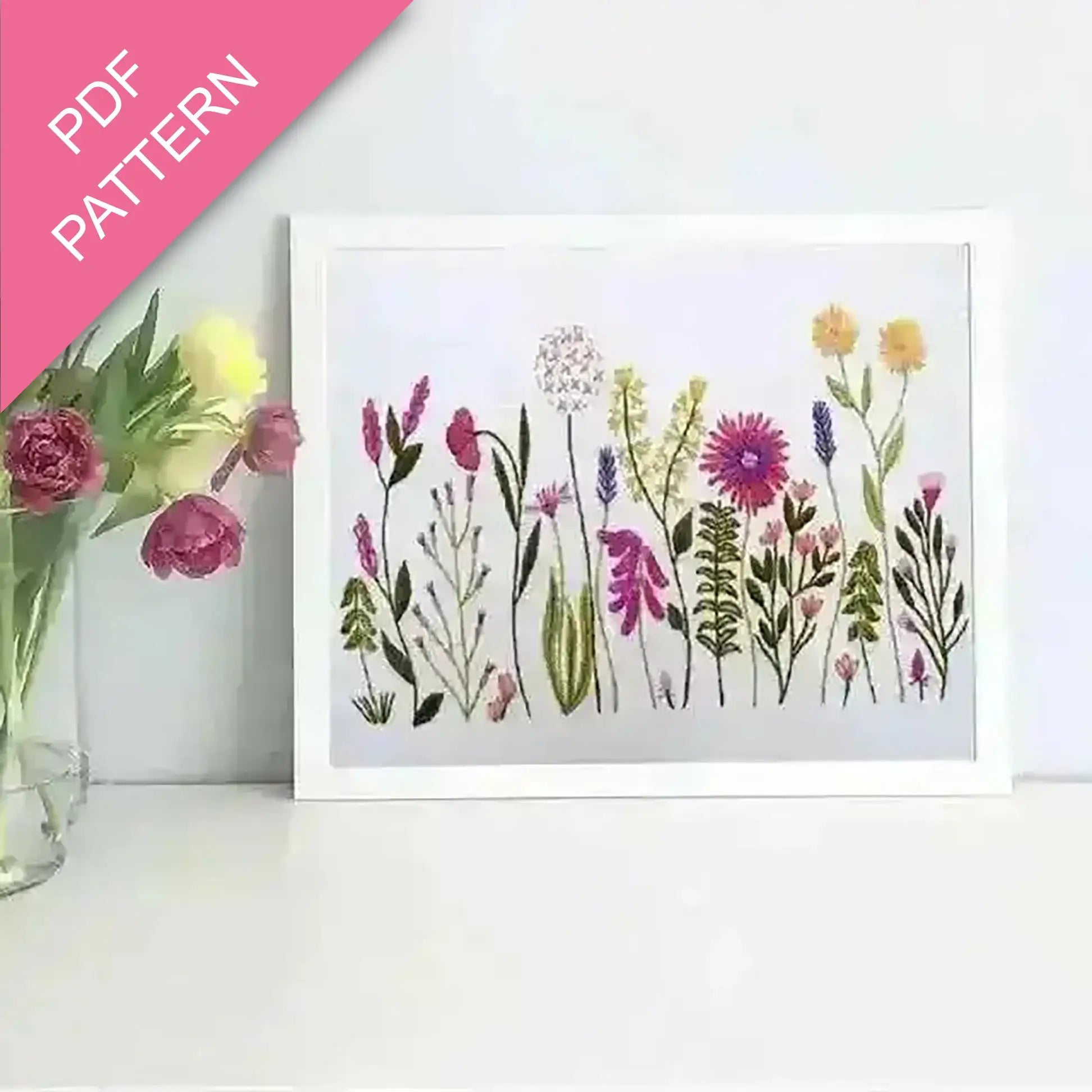 Framed artwork of colorful floral pattern with a pink triangle labeled 'PDF Pattern' on a white background.