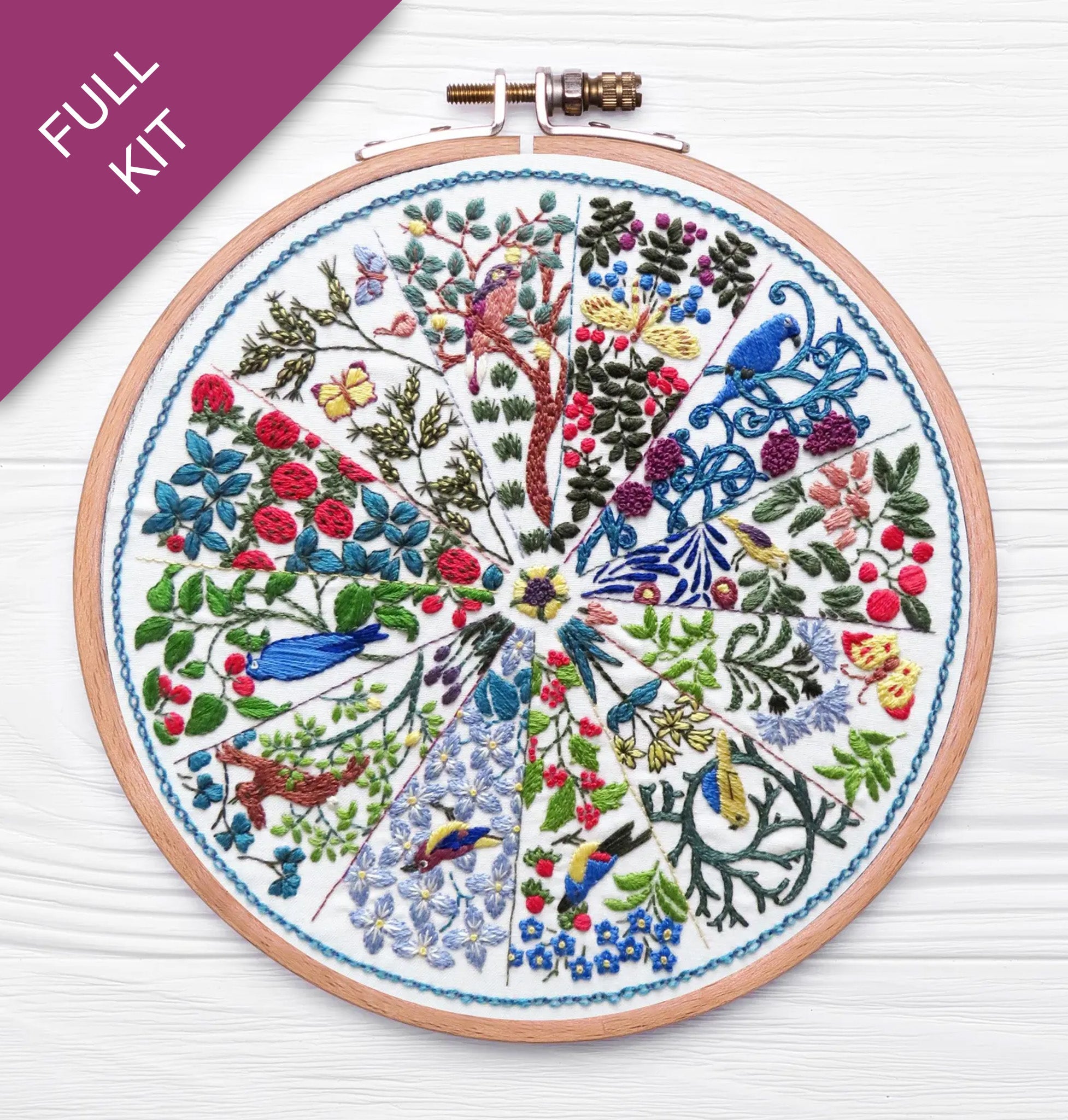 Embroidery hoop with a colorful floral and bird design on a white background