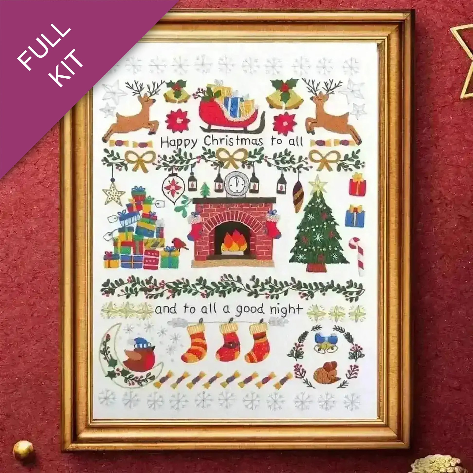 Framed Christmas-themed cross-stitch pattern with reindeer, fireplace, and stockings on a white background.