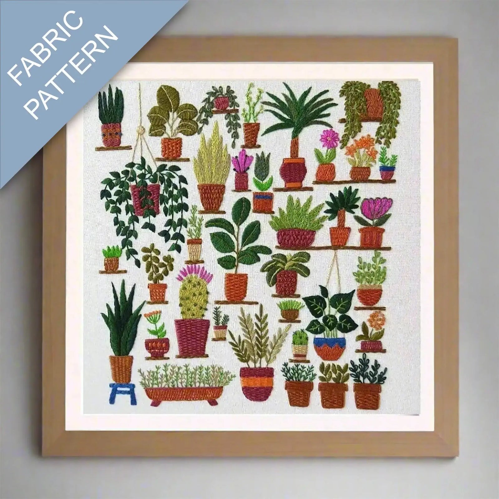 Framed fabric pattern with embroidered plants on a white background