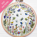 Embroidery hoop with floral and bird design on a white background