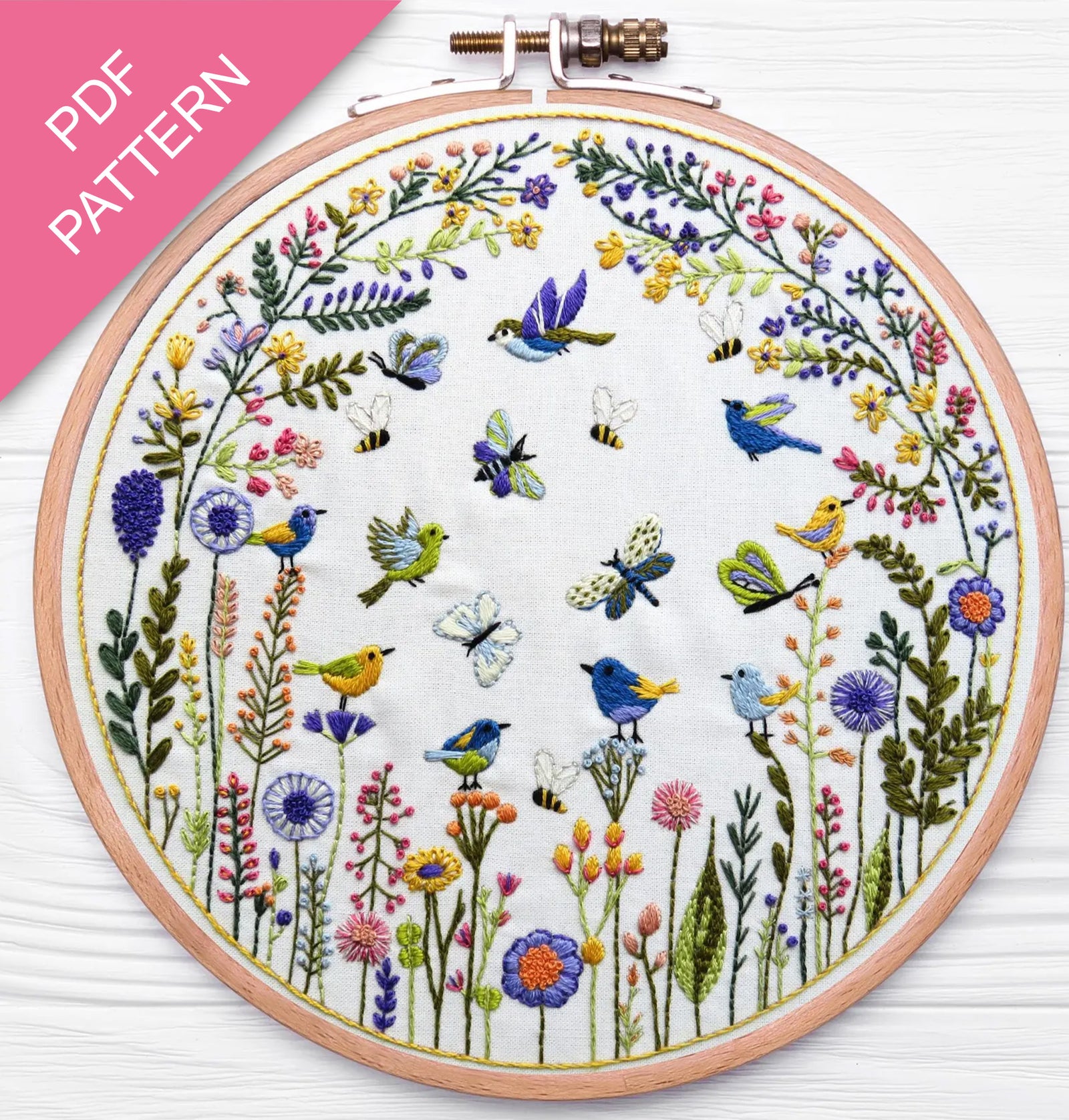 Embroidery hoop with floral and bird design on a white background