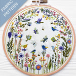Embroidery hoop with floral and bird pattern on a white background