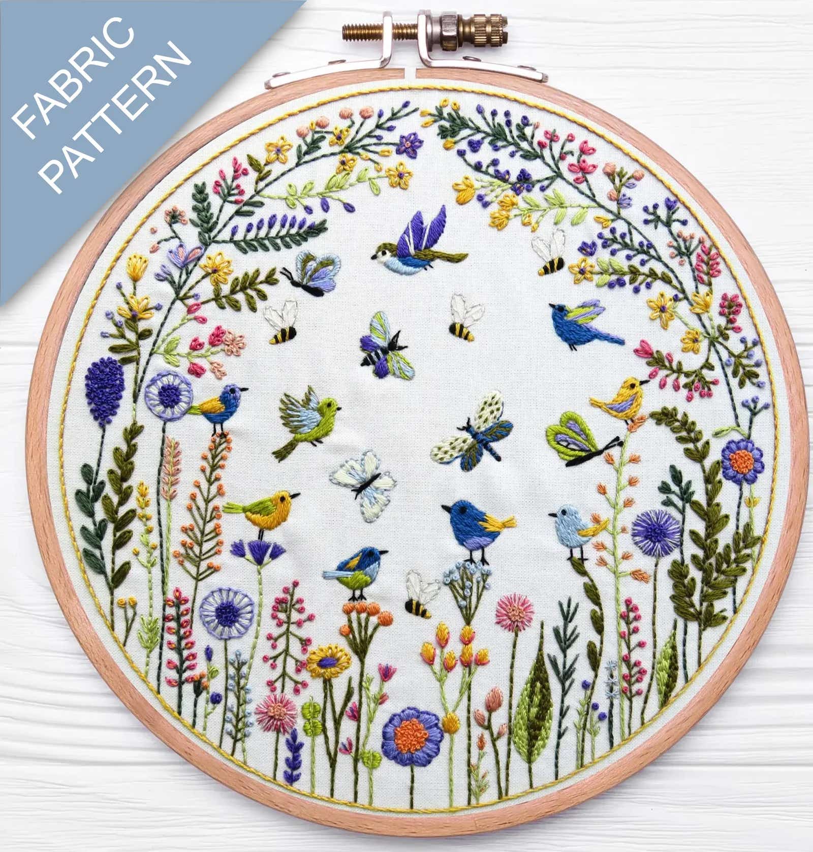 Embroidery hoop with floral and bird pattern on a white background