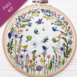 Embroidery hoop with floral and bird design on a white background