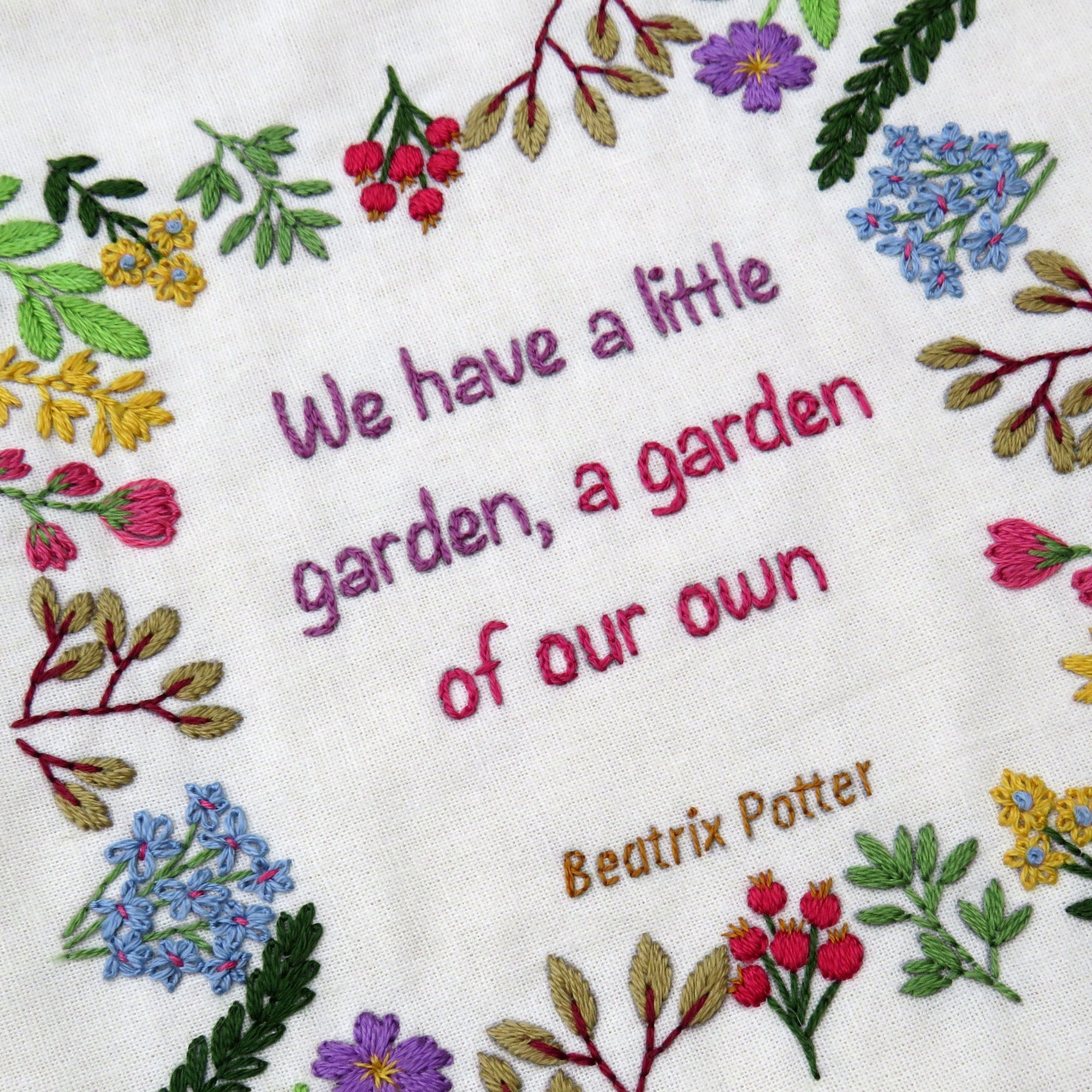 Embroidered floral design with text on a white background