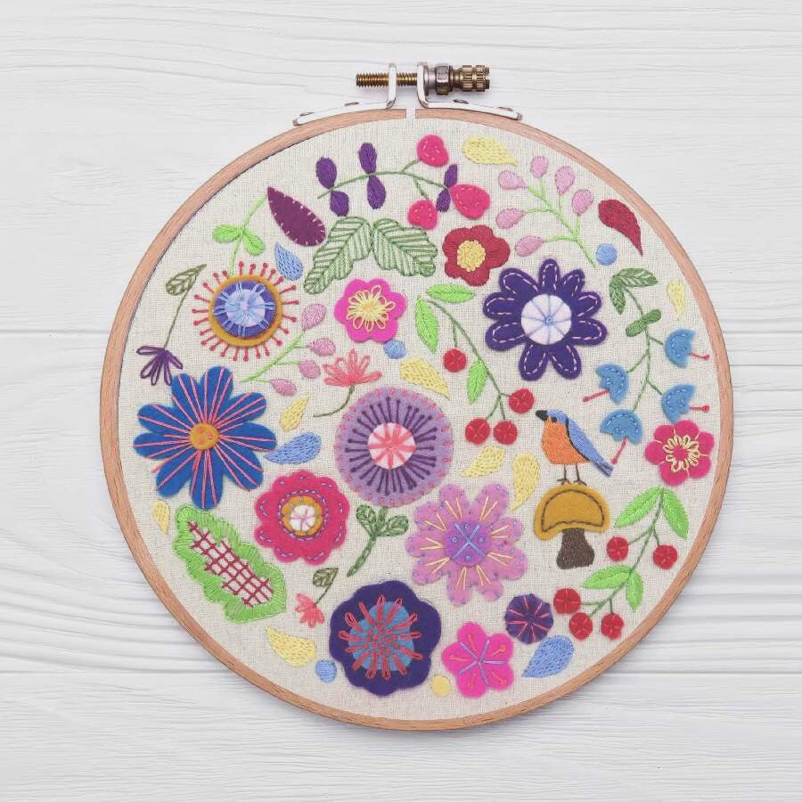 Embroidery hoop with colorful floral design on a white background