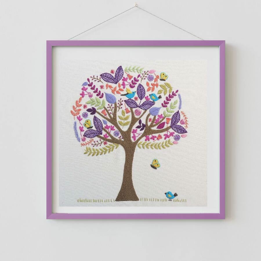 Colorful embroidered tree with birds and flowers on a white background