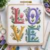Embroidery hoop with 'LOVE' letters surrounded by flowers on a white surface with embroidery supplies.