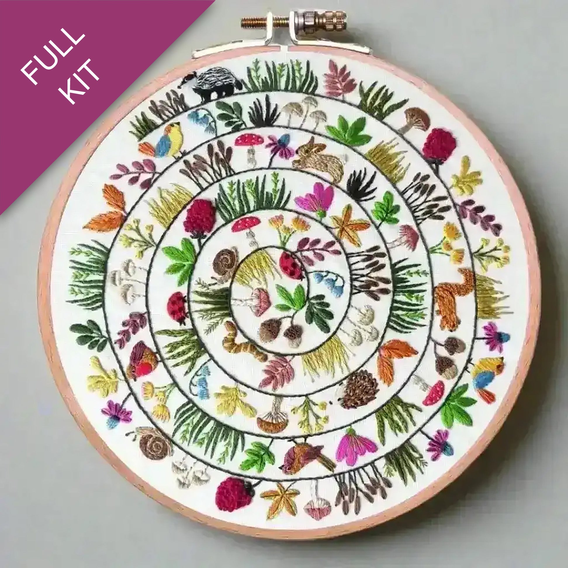 Embroidery hoop with a colorful floral and animal design on a gray background
