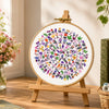 Decorative circular artwork with floral patterns on a wooden stand in a home setting.
